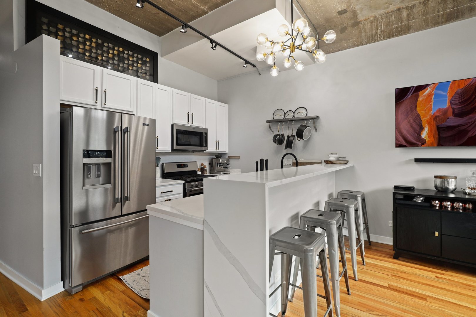 1111 West 15th Street, Unit 113 Chicago, IL 60608 - Photo 12 of 34 a kitchen with stainless steel appliances a refrigerator a stove a sink dishwasher a dining table and chairs with wooden floor