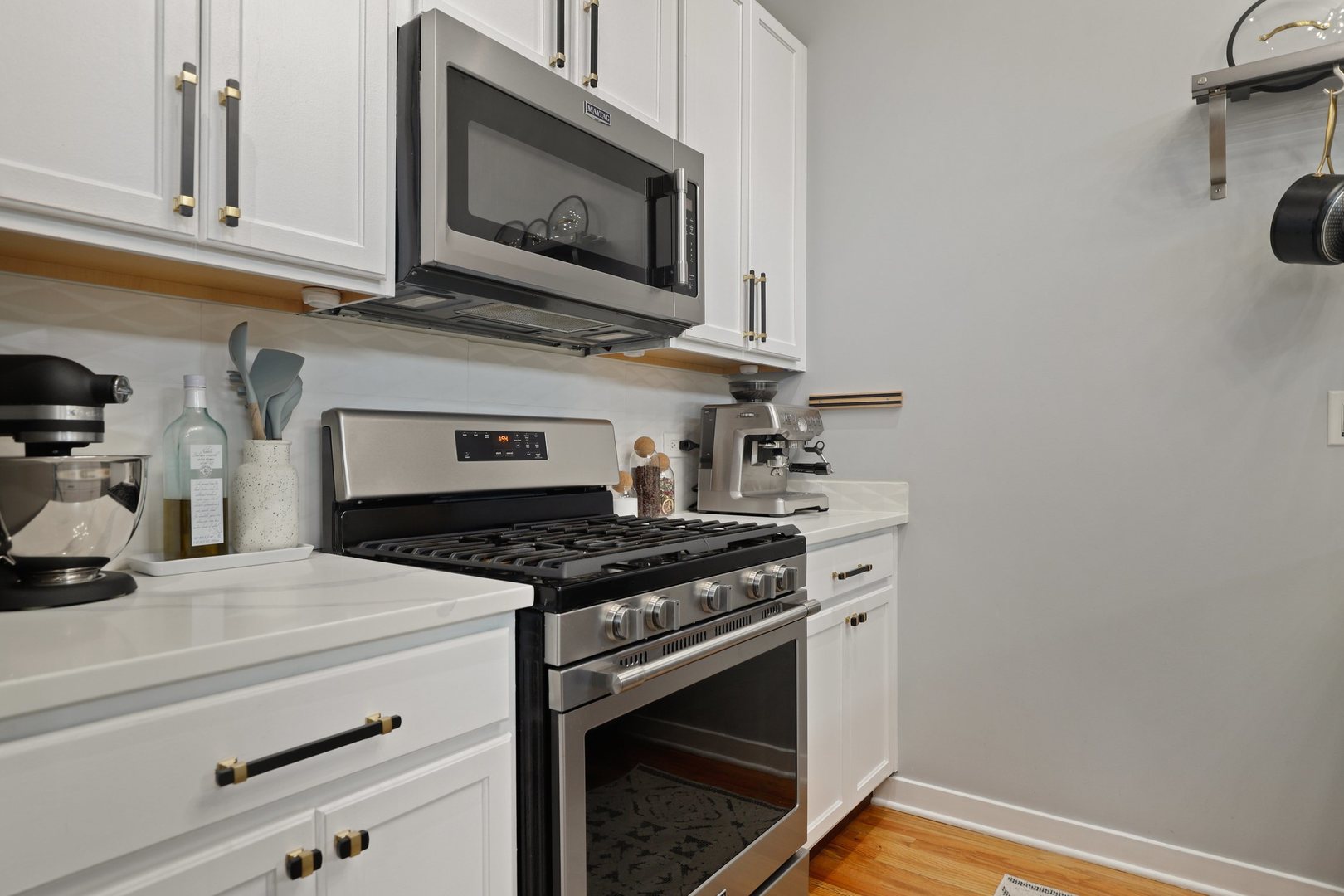 1111 West 15th Street, Unit 113 Chicago, IL 60608 - Photo 13 of 34 a kitchen with granite countertop cabinets stainless steel appliances and a wooden floor
