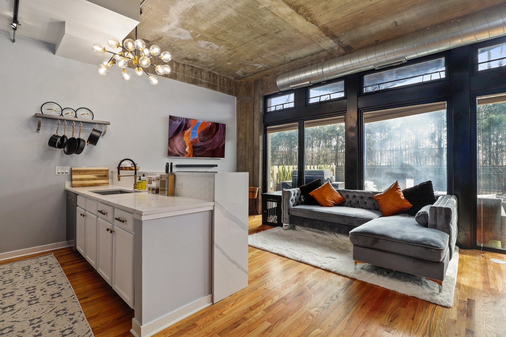 1111 West 15th Street, Unit 113 Chicago, IL 60608 - Photo 8 of 34 a living room with furniture and a chandelier