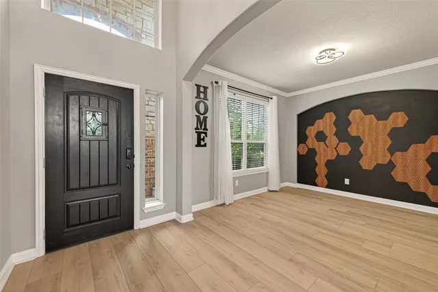 a view of an empty room with painting on the wall and a window