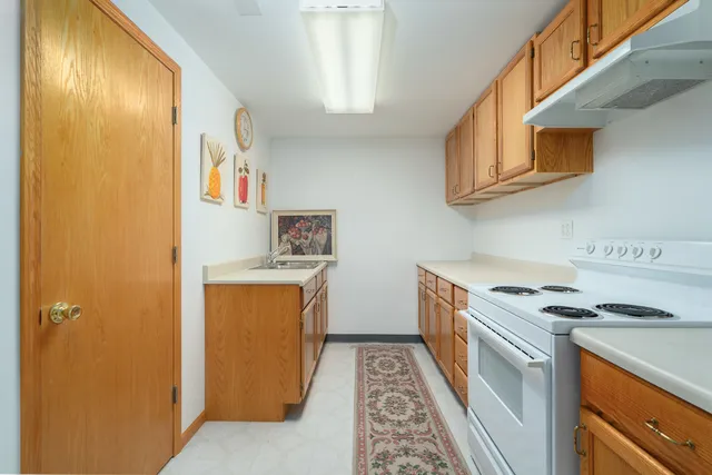a kitchen with stainless steel appliances granite countertop a stove a sink and a refrigerator
