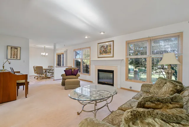 a living room with furniture large window and a fireplace