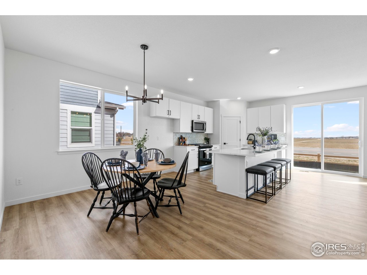 797 Muturu Road Johnstown, CO 80534 - Photo 11 of 26 a view of a dining room with furniture window and wooden floor