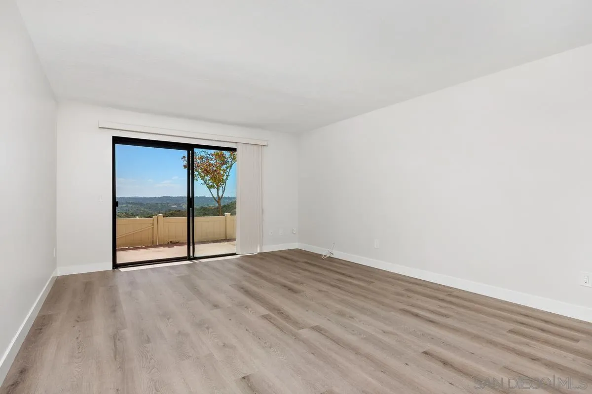 245 Fairlee Lane Encinitas, CA 92024 - Photo 9 of 18 an empty room with wooden floor and windows