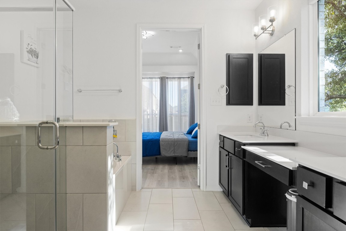 1132 Spring Gulch Lane Georgetown, TX 78628 - Photo 20 of 36 a bathroom with a tub sink and mirror