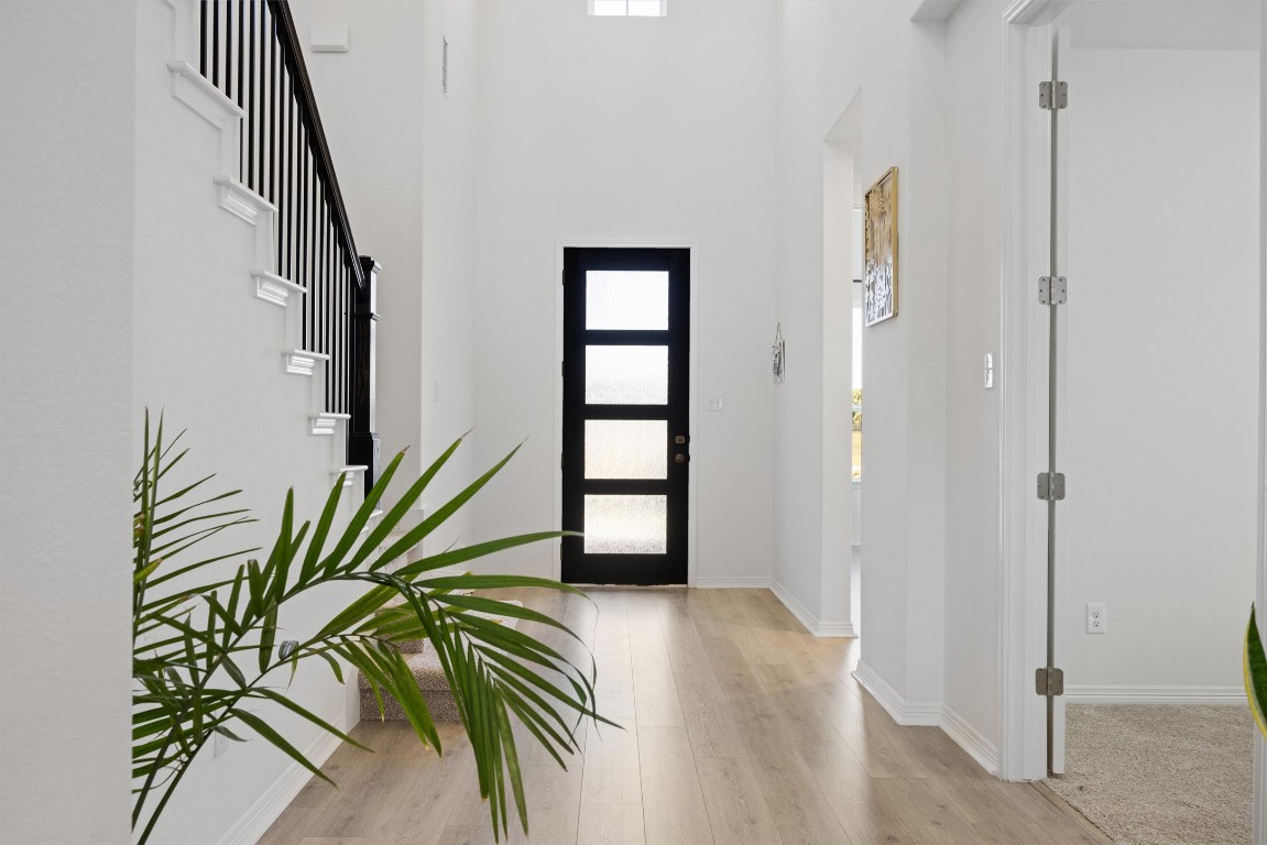 1132 Spring Gulch Lane Georgetown, TX 78628 - Photo 2 of 36 a view of a hallway with wooden floor and stairs