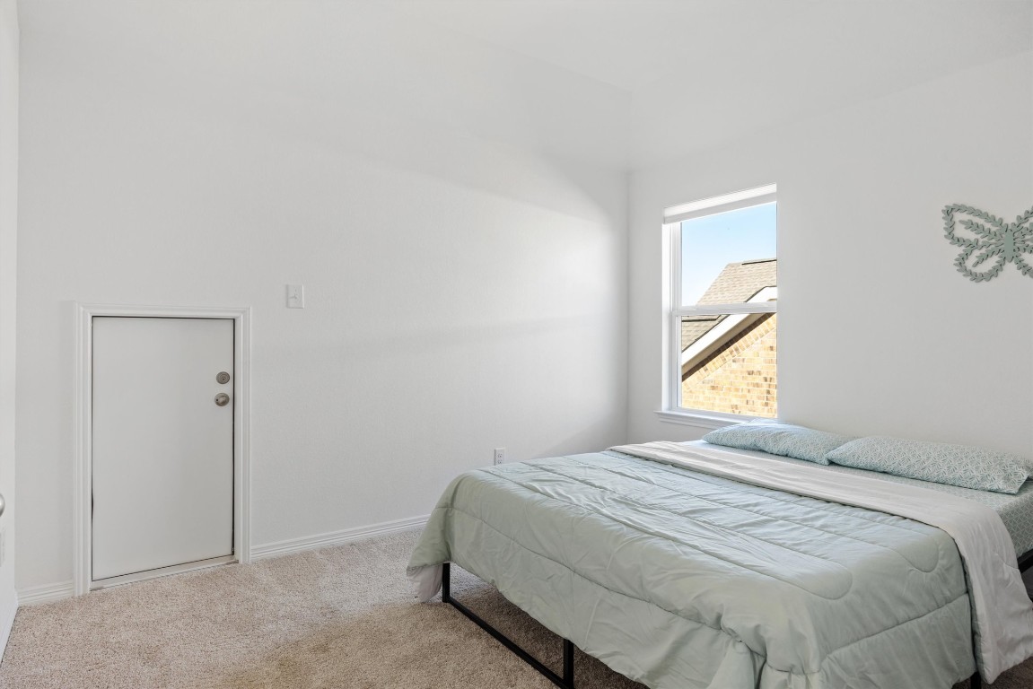1132 Spring Gulch Lane Georgetown, TX 78628 - Photo 23 of 36 a bedroom with a bed and window