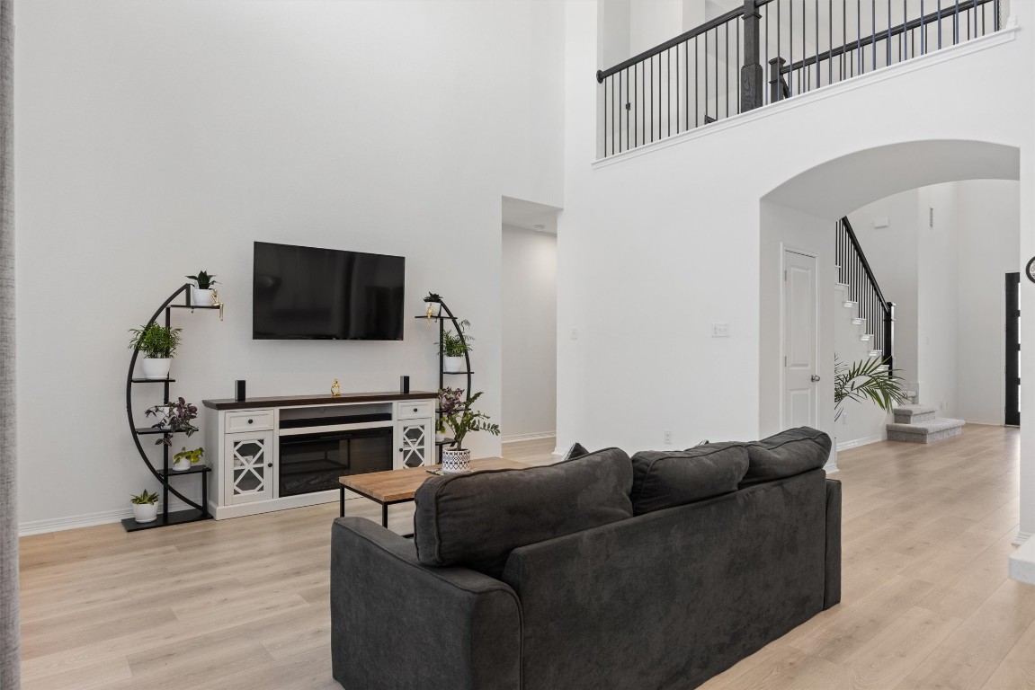 1132 Spring Gulch Lane Georgetown, TX 78628 - Photo 9 of 36 a living room with furniture a flat screen tv and a fireplace