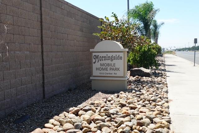 a sign that is sitting in front of a brick wall