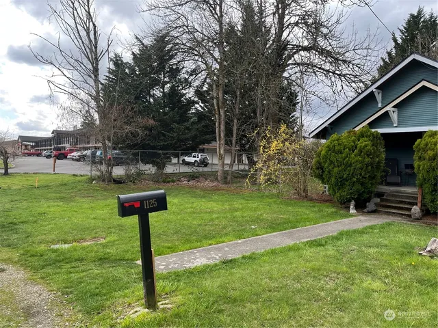 a front view of a house with a garden and trees