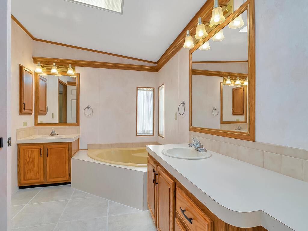 269 Riverwood Road Naples, FL 34114 - Photo 18 of 32 a bathroom with a tub a sink and a mirror