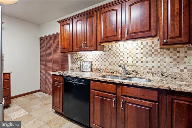 a kitchen with stainless steel appliances granite countertop a refrigerator and wooden cabinets