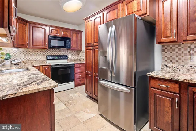 a kitchen with stainless steel appliances granite countertop a sink stove and microwave