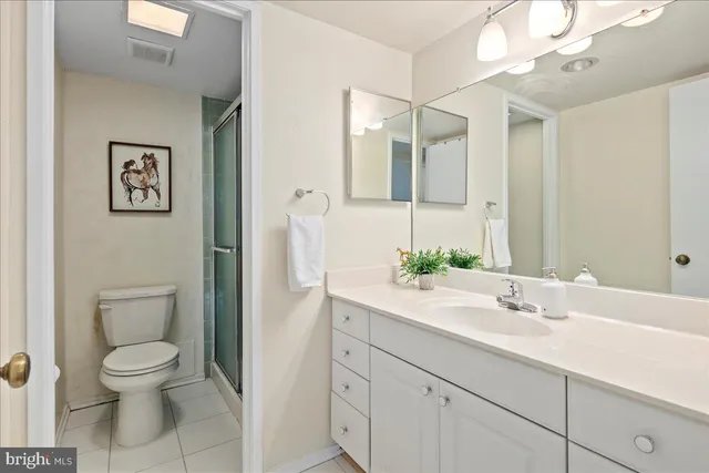 a bathroom with a sink double vanity granite tub shower and a mirror