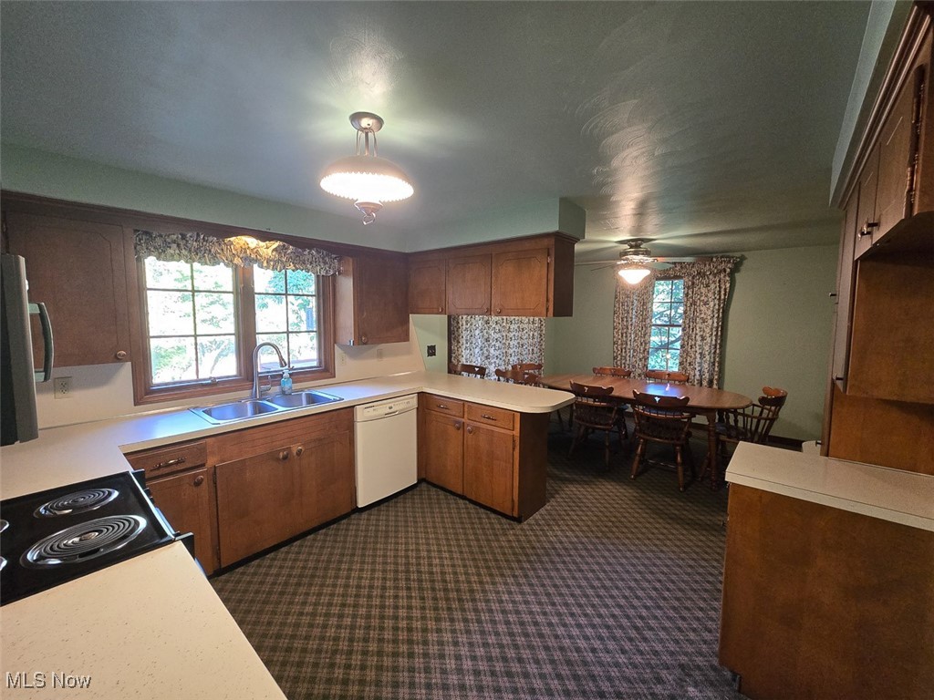 715 Minerva Road Magnolia, OH 44643 - Photo 10 of 26 Kitchen with light countertops, dishwasher, stainless steel microwave, a peninsula, and electric range