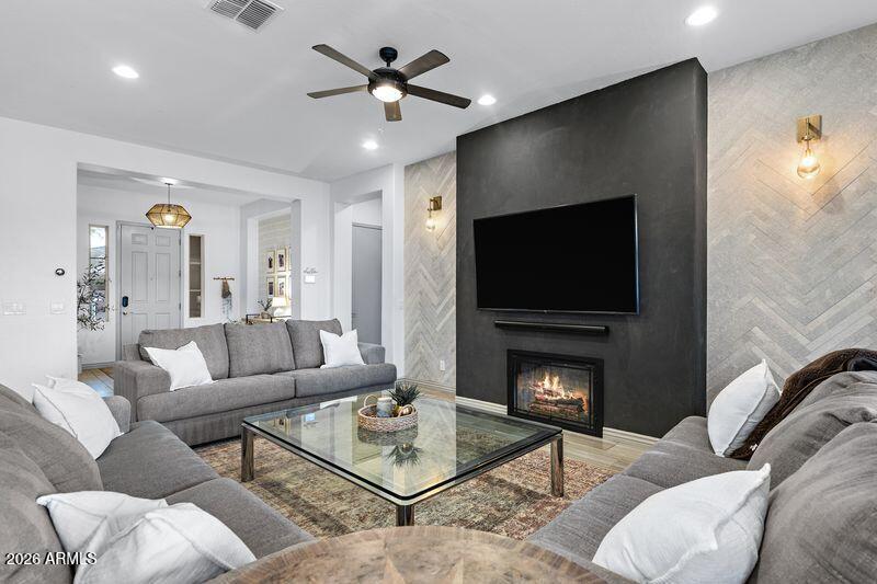 7871 South Stuart Avenue Gilbert, AZ 85298 - Photo 6 of 77 a living room with furniture a flat screen tv and a fireplace