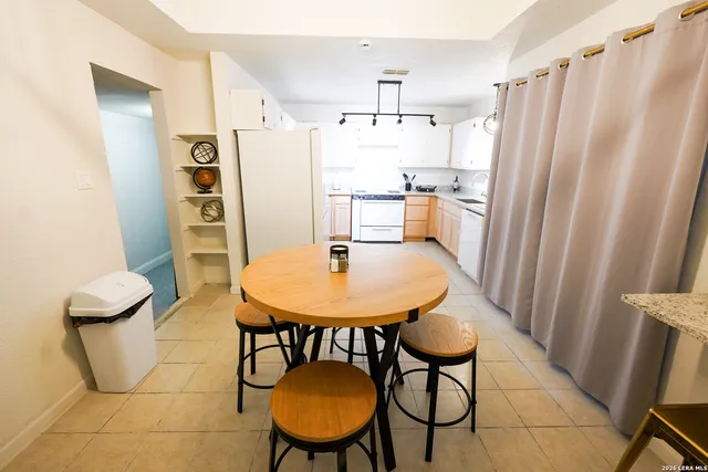 a kitchen with stainless steel appliances a table and a refrigerator