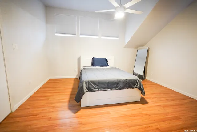 a bedroom with a bed and wooden floor