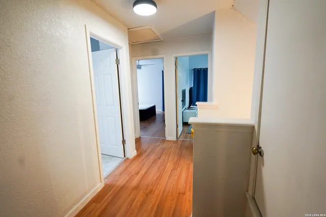 a view of a hallway with wooden floor