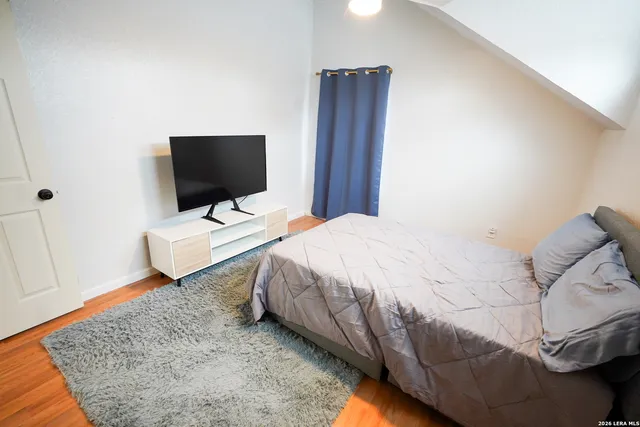 a bedroom with a bed and flat screen tv