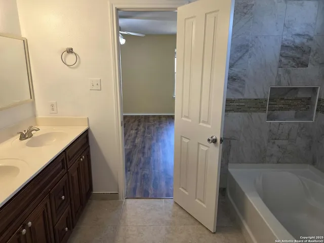 a bathroom with a tub sink and mirror