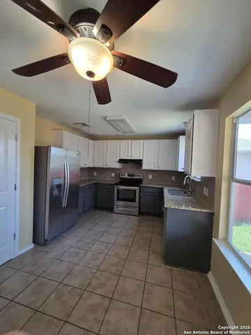a kitchen with stainless steel appliances granite countertop a sink and a refrigerator