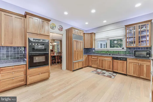 a spacious bedroom with a bed a couch and a chandelier