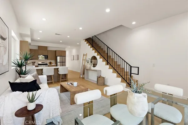 a living room with furniture kitchen view and a potted plant