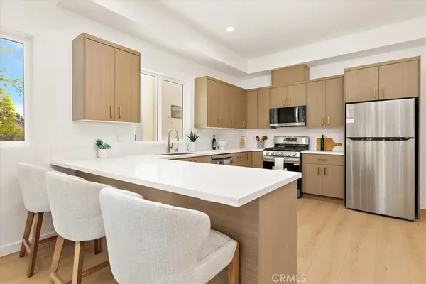 a kitchen with kitchen island a dining table and chairs