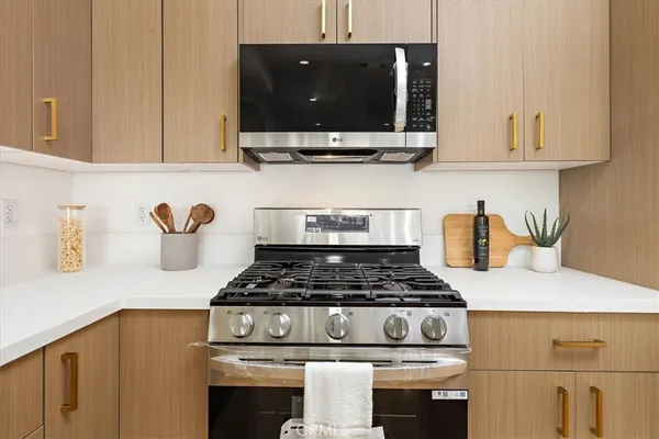 a kitchen with a refrigerator a stove a sink a counter top space and cabinets
