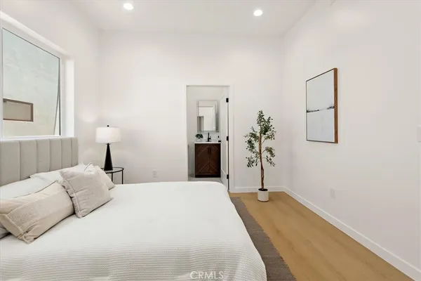 a view of a bedroom with a bed and wooden floor
