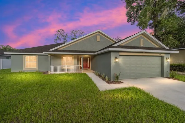 a front view of a house with yard and green space