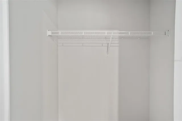 an empty room with a hallway and closet