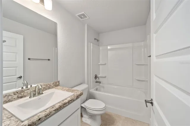 a view of a house with a big yard and large trees