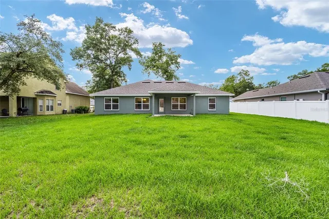 an aerial view of a house with a yard lake outdoor and green space