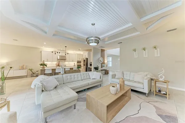 a bedroom with a bed a chandelier and a large mirror on the dresser