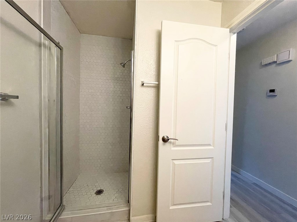 1834 North Decatur Boulevard, Unit 204 Las Vegas, NV 89108 - Photo 8 of 17 A sleek shower enclosure with intricate hexagonal tile flooring promises a revitalizing experience.