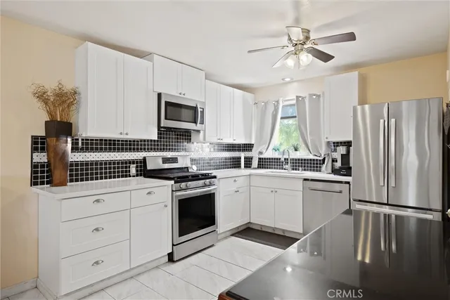 a kitchen with white cabinets and white appliances
