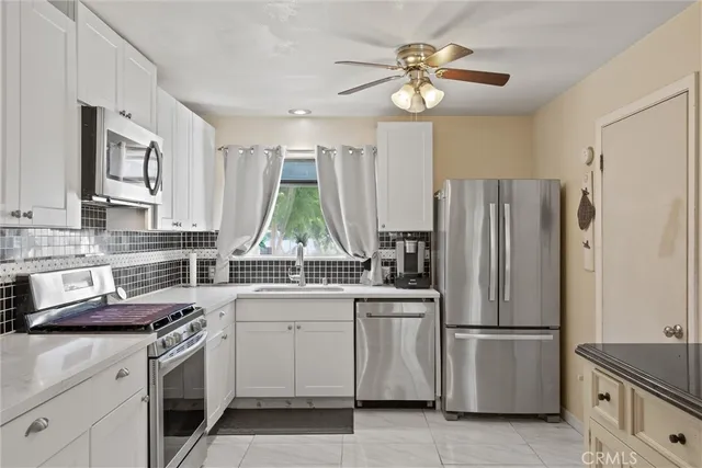 a kitchen with white cabinets and stainless steel appliances
