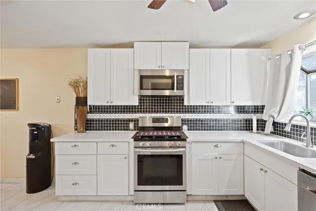 a kitchen with white cabinets and appliances