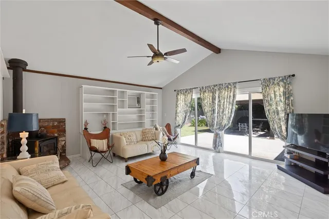a living room with furniture a flat screen tv and a floor to ceiling window
