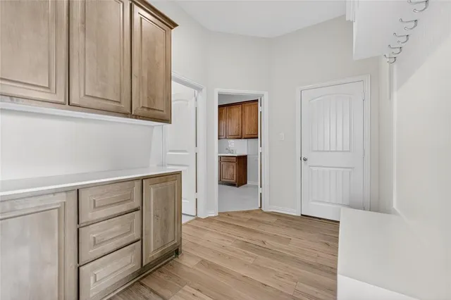 a hallway with cabinets and wooden floor