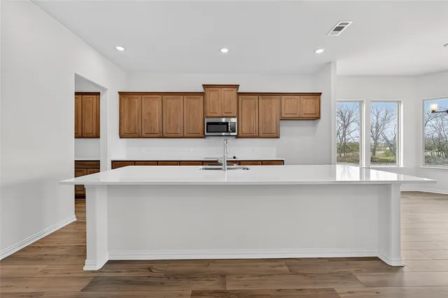 a kitchen with stainless steel appliances granite countertop a sink a stove a microwave a counter top and cabinets