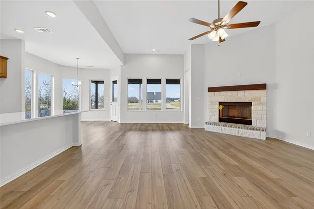 wooden floor fireplace and windows in an empty room