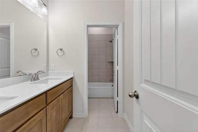 a bathroom with a granite countertop sink a mirror and a bathtub