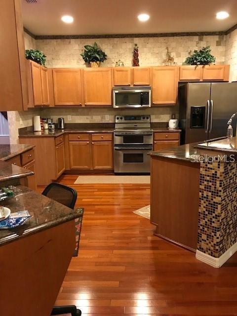5948 Winchester Isle Road Orlando, FL 32829 - Photo 6 of 23 a kitchen with granite countertop a stove and cabinets