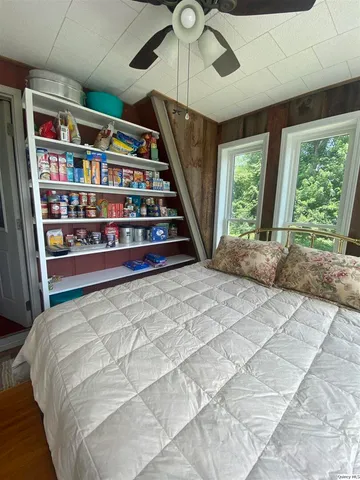 a bed sitting in a bedroom next to a book shelf