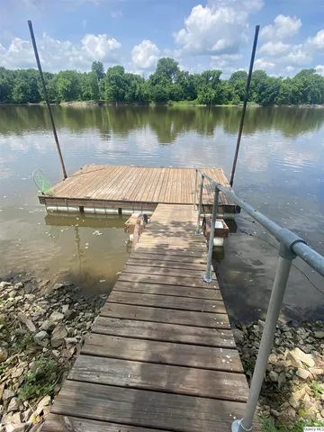 a view of a lake with a yard and large trees
