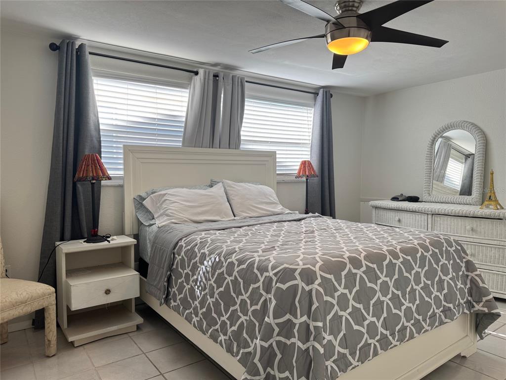 11234 Linden Lane Port Richey, FL 34668 - Photo 16 of 25 a bedroom with a bed and a lamp on table chair