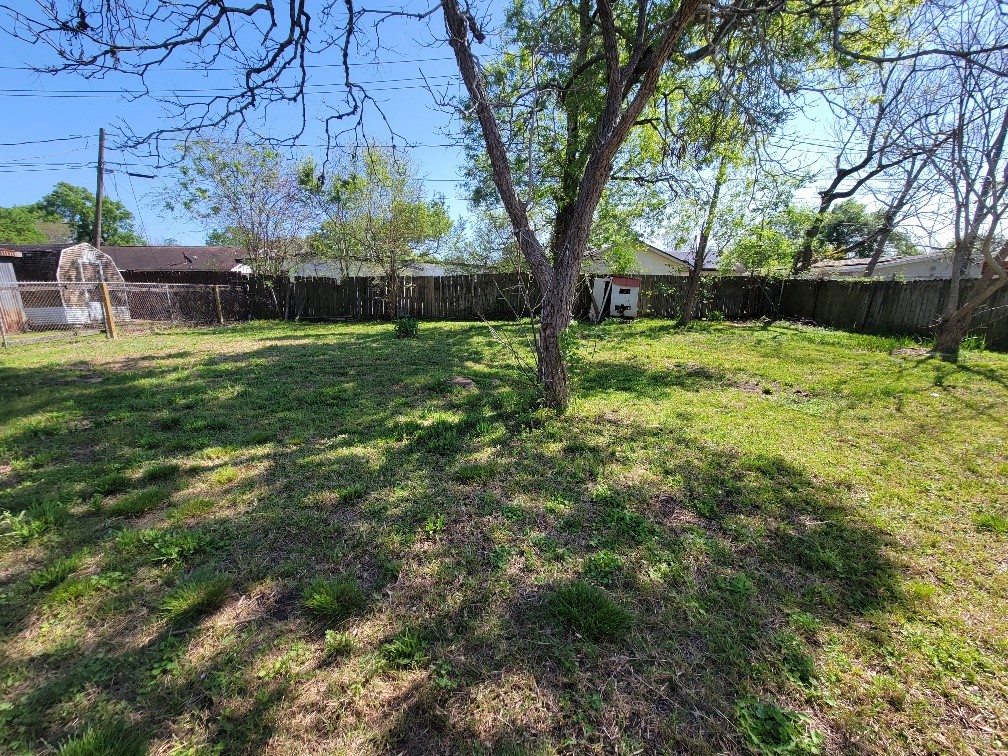 705 Inwood Drive Baytown, TX 77521 - Photo 3 of 15 a view of backyard with table and chairs and a large tree